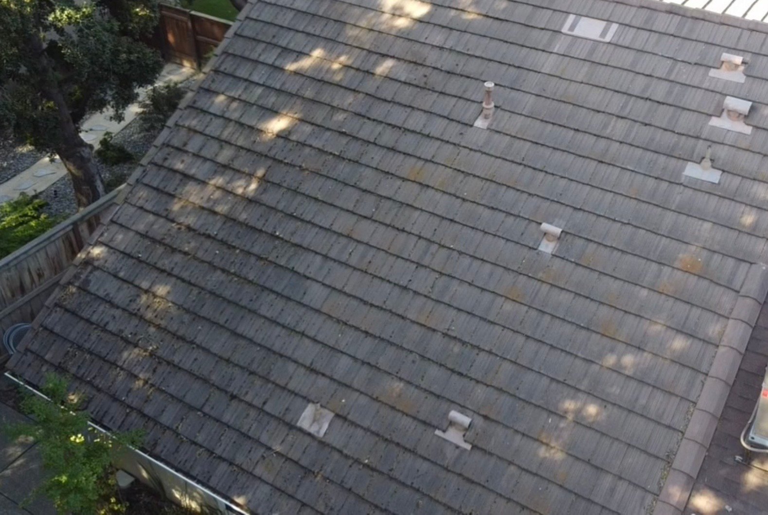 Dusty, dirt-streaked tile roof before cleaning
